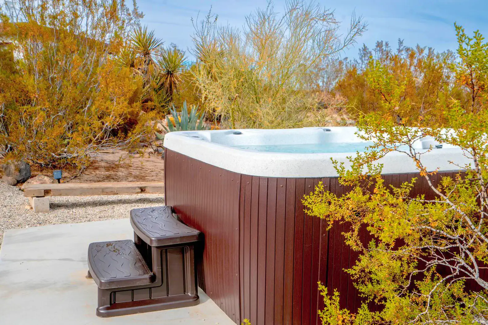 Hot tub surrounded by desert vegetation and shrubs
