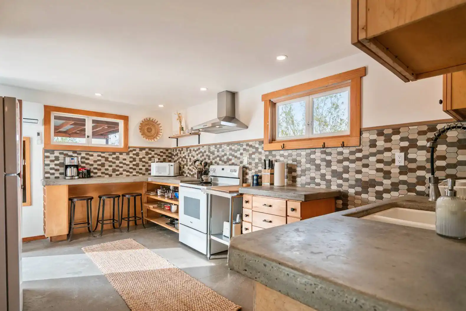 Modern kitchen with stainless steel appliances and mosaic tile backsplash