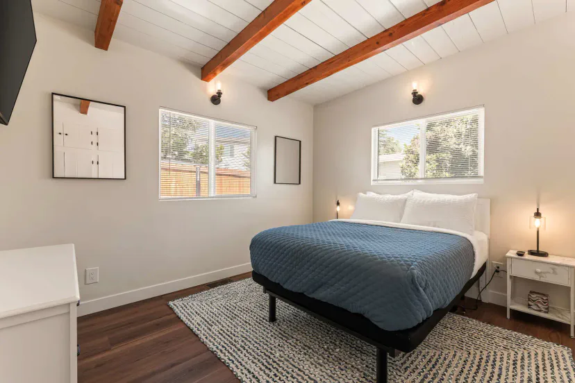 Guest bedroom with double bed, smart TV, dresser and storage