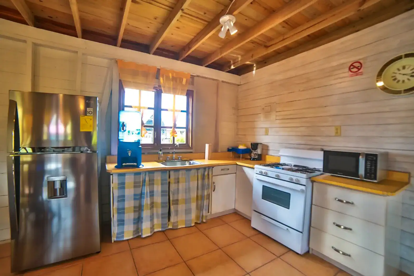 Bright kitchen with stainless steel appliances and wooden ceiling