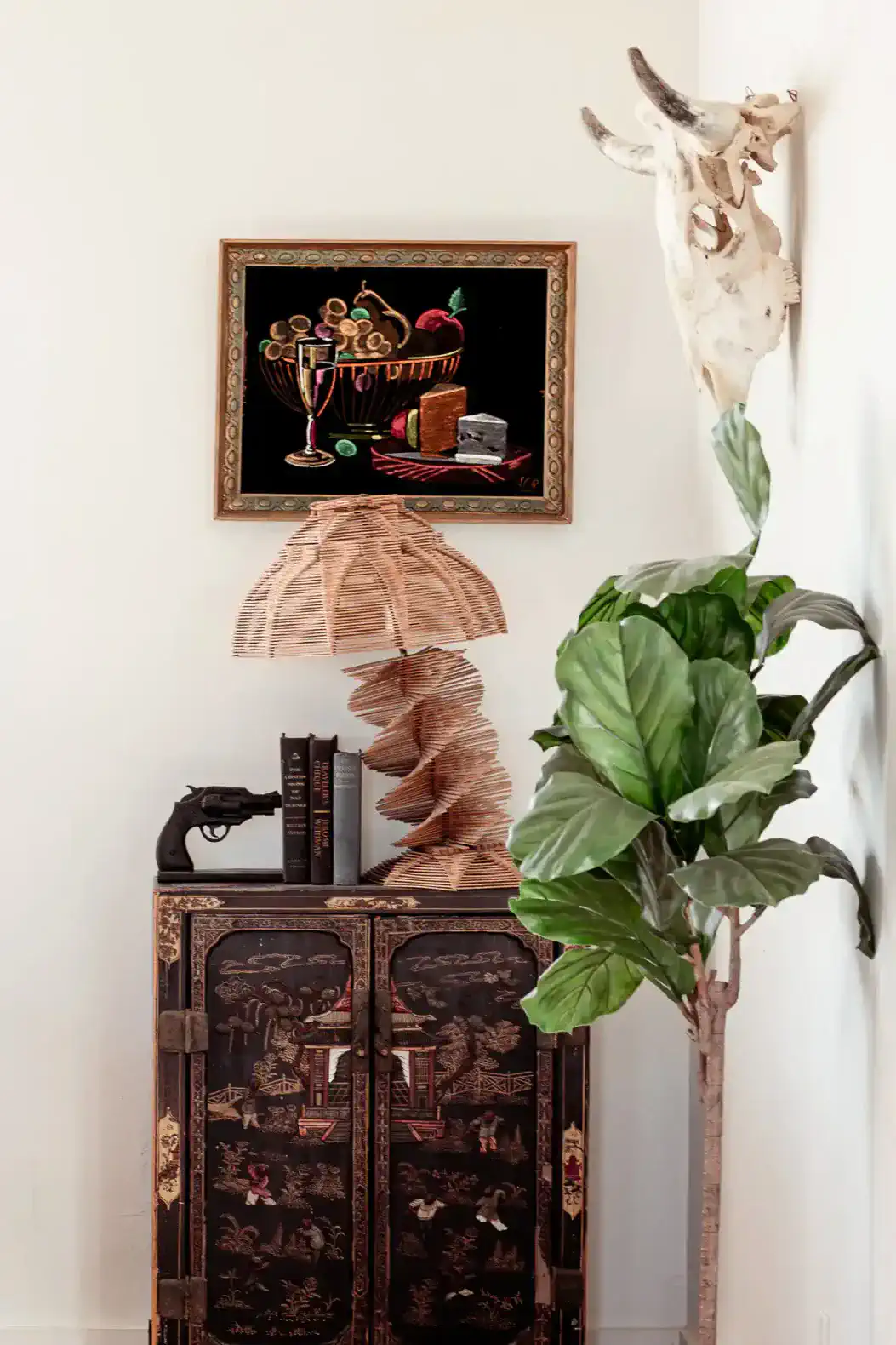 Decorative corner with a unique lamp, artwork, and a potted plant