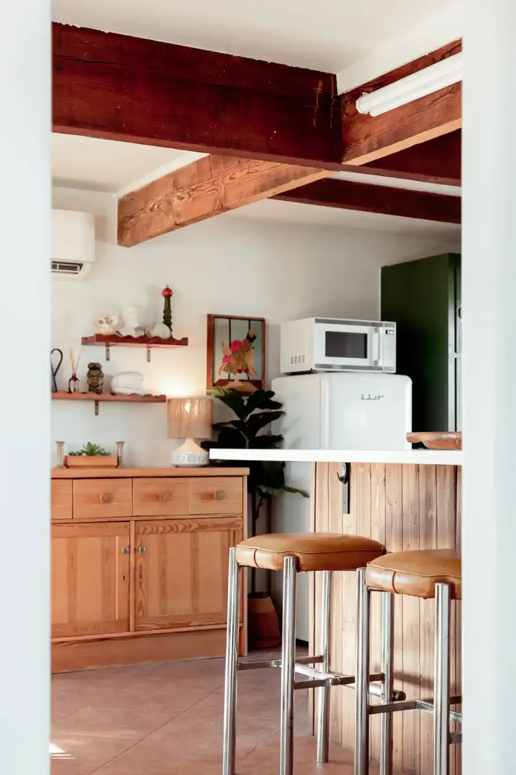 Cozy kitchen featuring wooden cabinetry, bar stools, and modern appliances