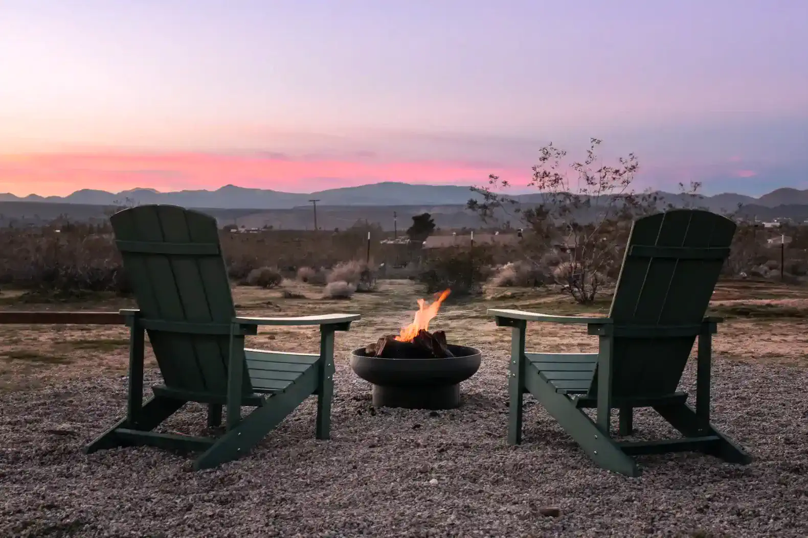 Cozy outdoor seating with fire pit and mountain view at sunset