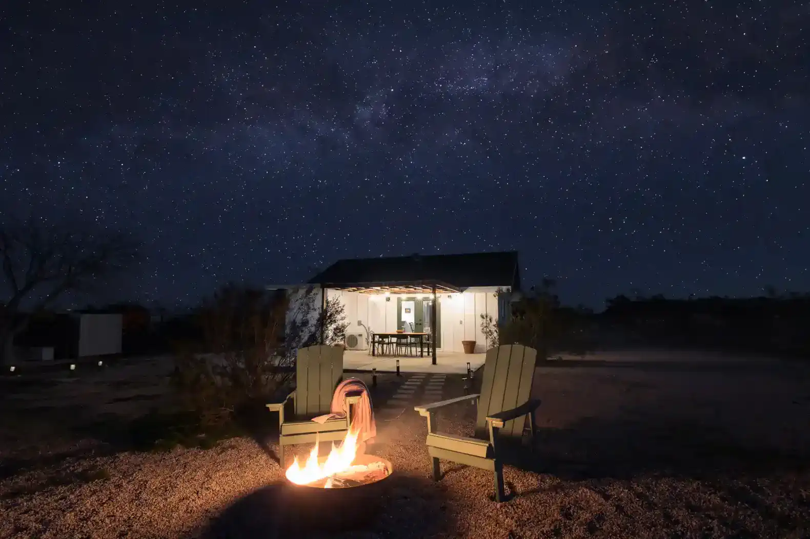 Cozy outdoor seating by a fire pit under a starry night sky
