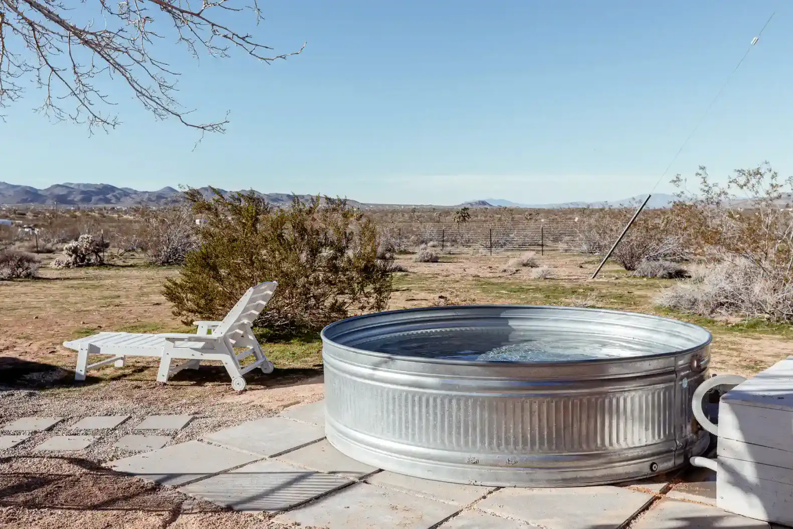 Outdoor hot tub with scenic desert views and a lounge chair nearby