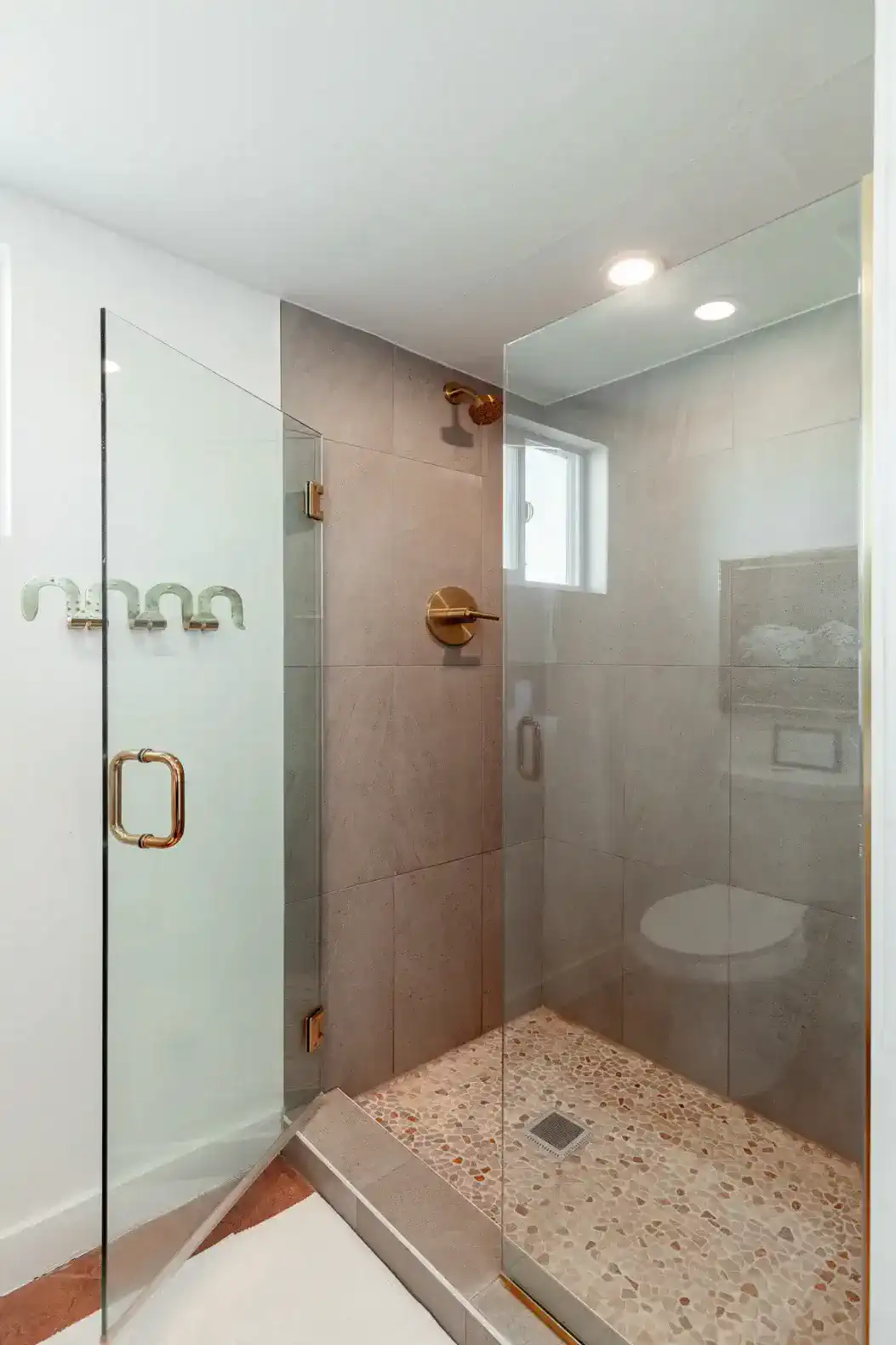 Modern shower with glass enclosure and pebble stone floor