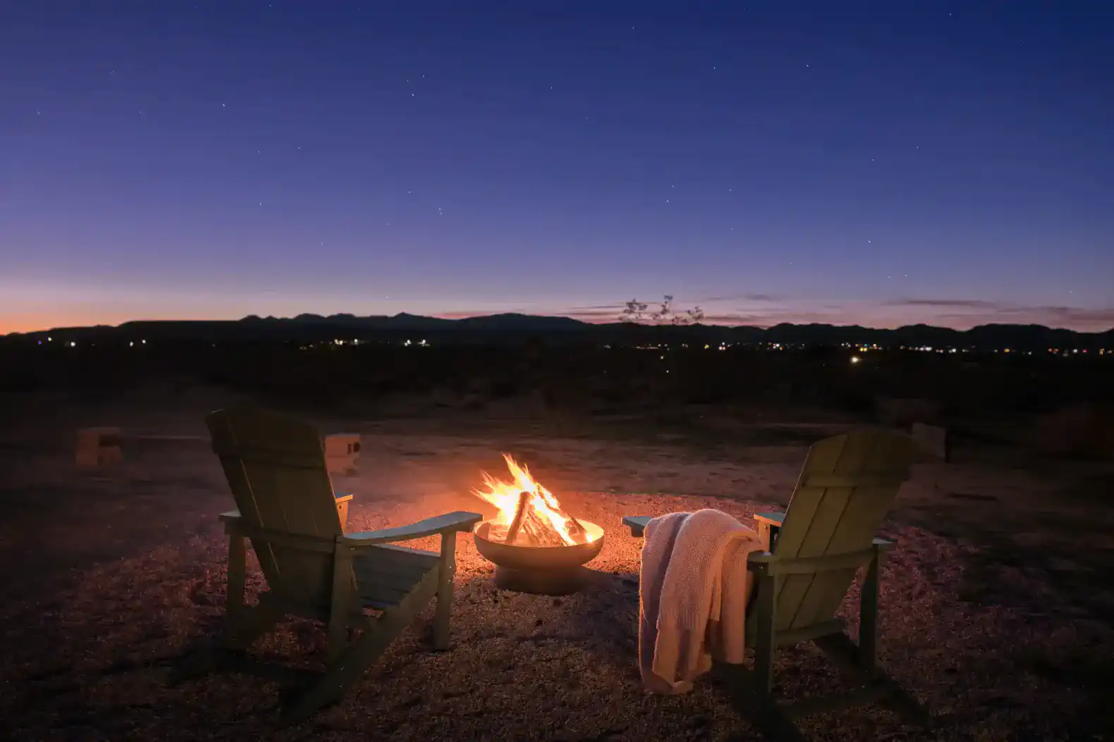 Cozy outdoor seating with a fire pit under a starry sky