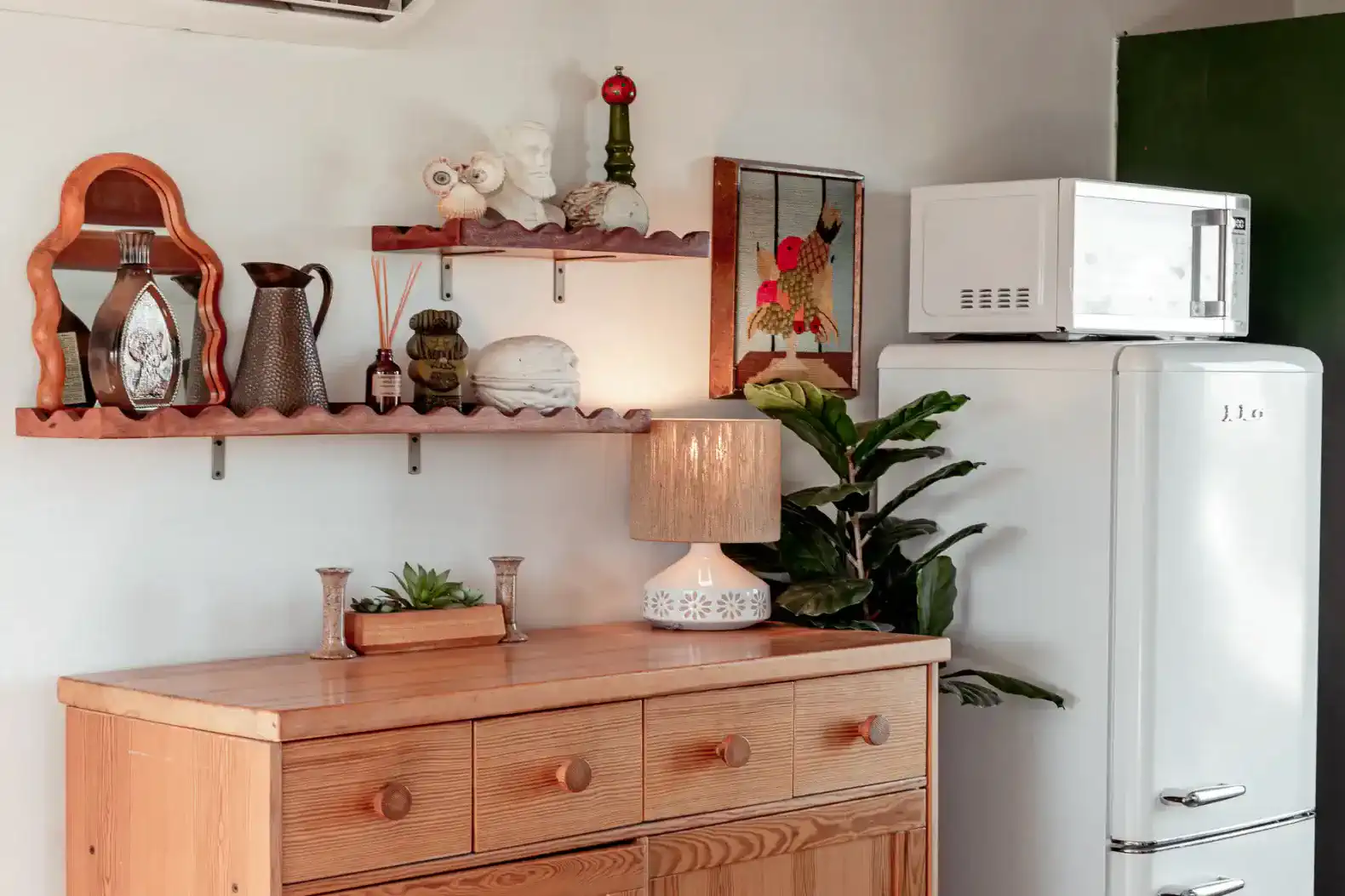 Stylish kitchen corner with wooden dresser, decorative items, and a retro refrigerator
