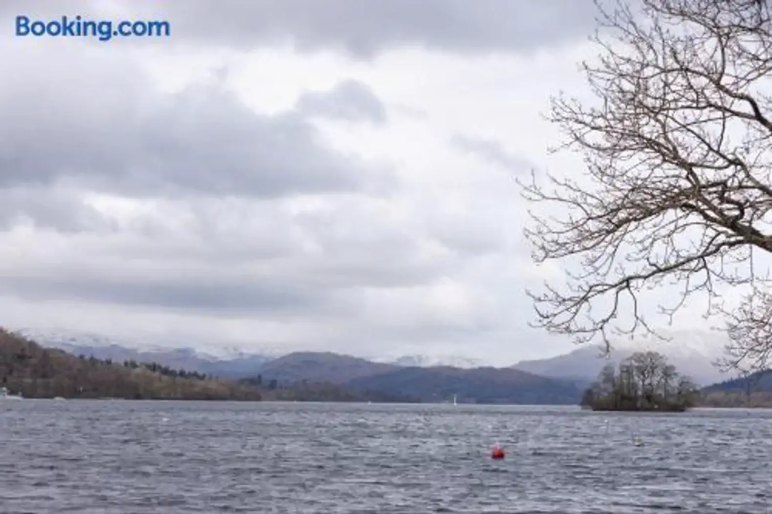 Scenic view of the lake with mountains in the background and a cloudy sky