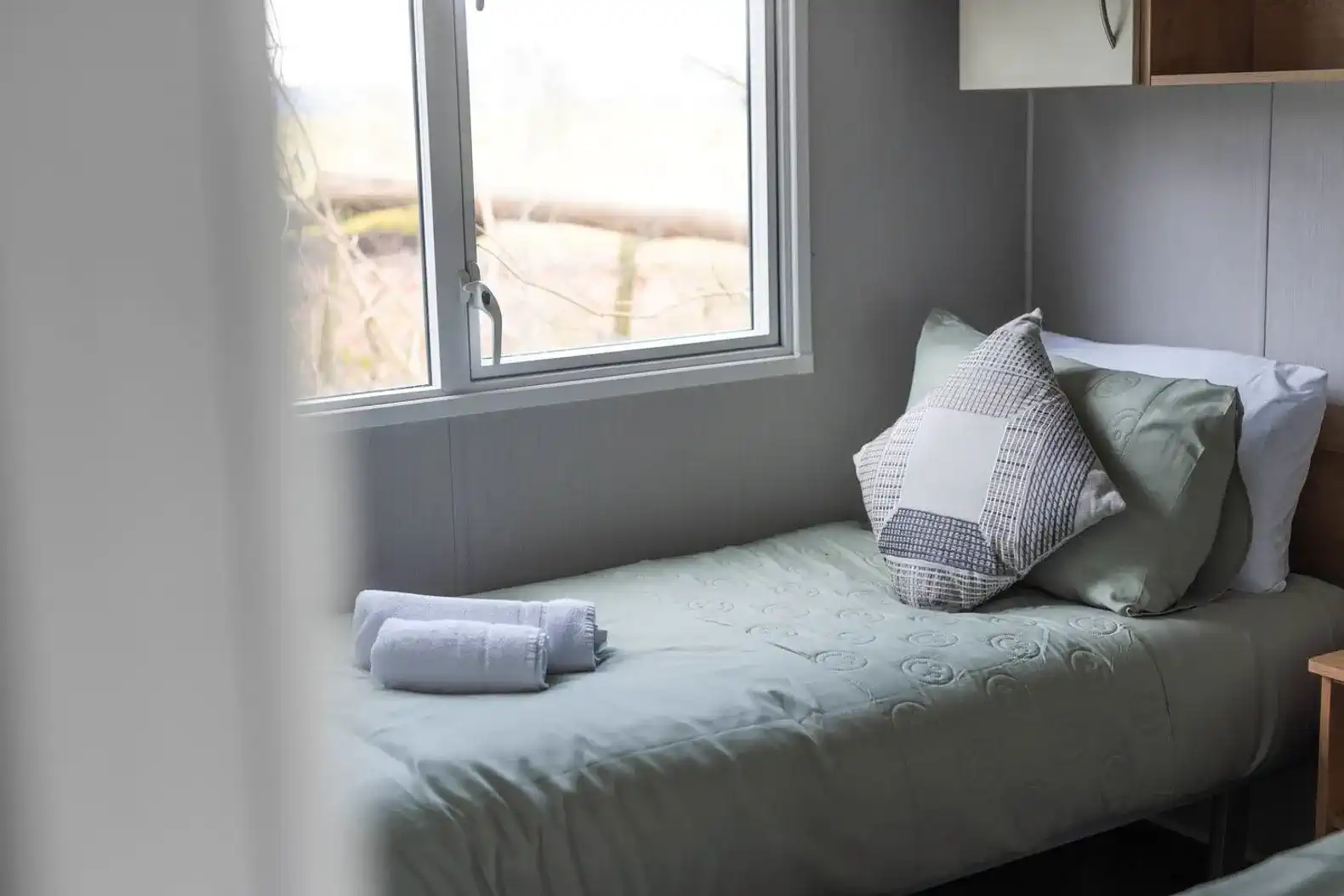 Relax in two single beds featuring premium linens for a hotel-quality sleep. This room is "long-stay ready," equipped with a full wardrobe and drawers to keep your belongings organised and your stay clutter-free