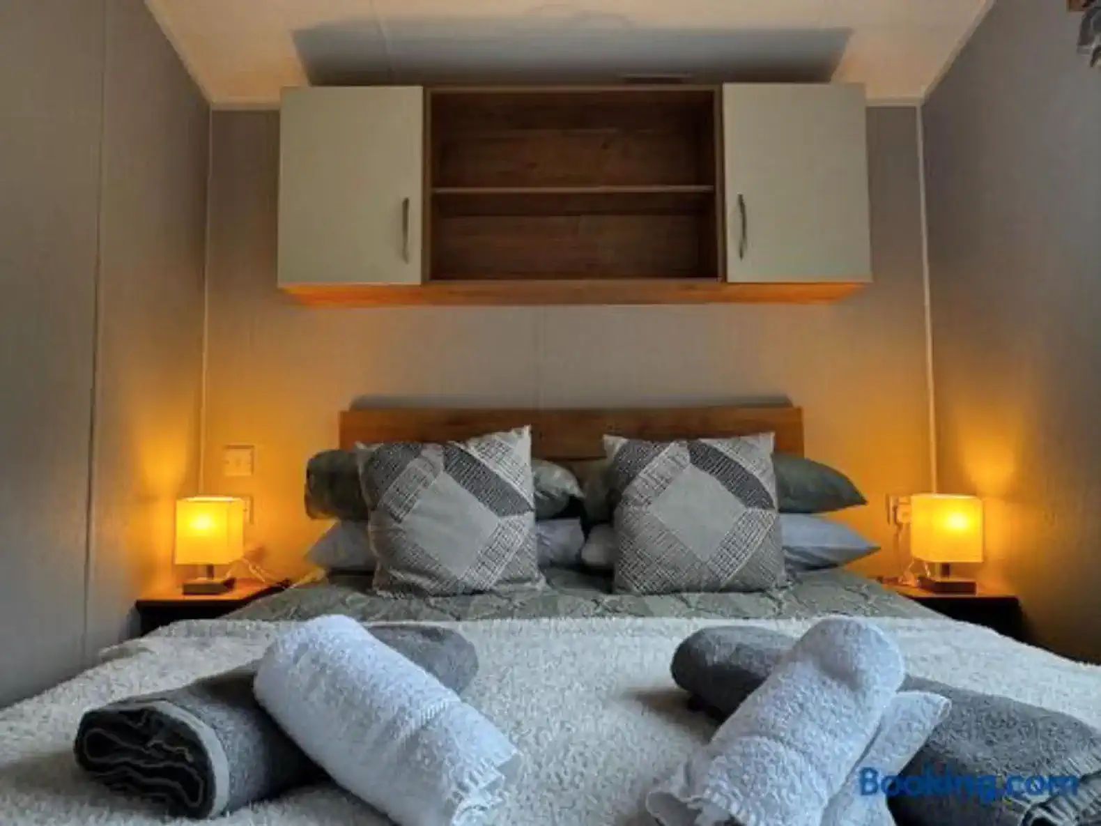 Cozy bedroom with a double bed, decorative pillows, and soft lighting