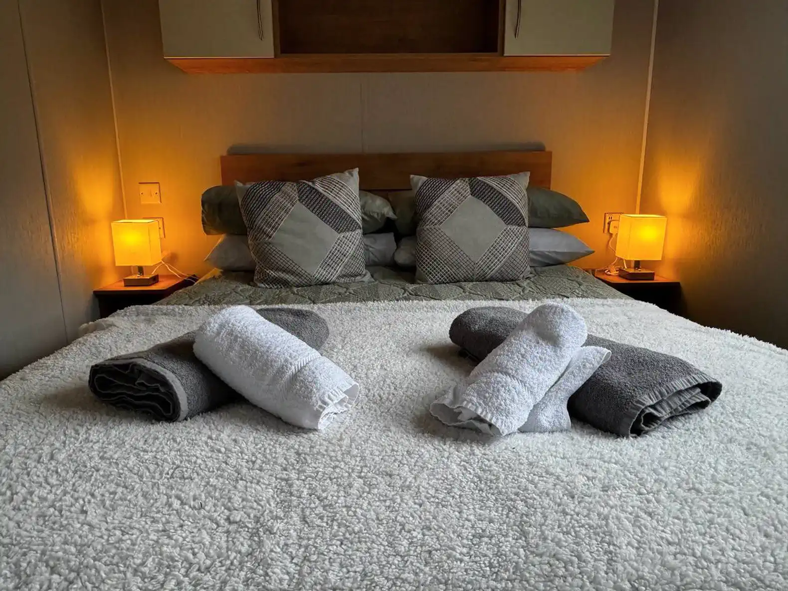 Cozy master bedroom with soft bedding and warm bedside lamps