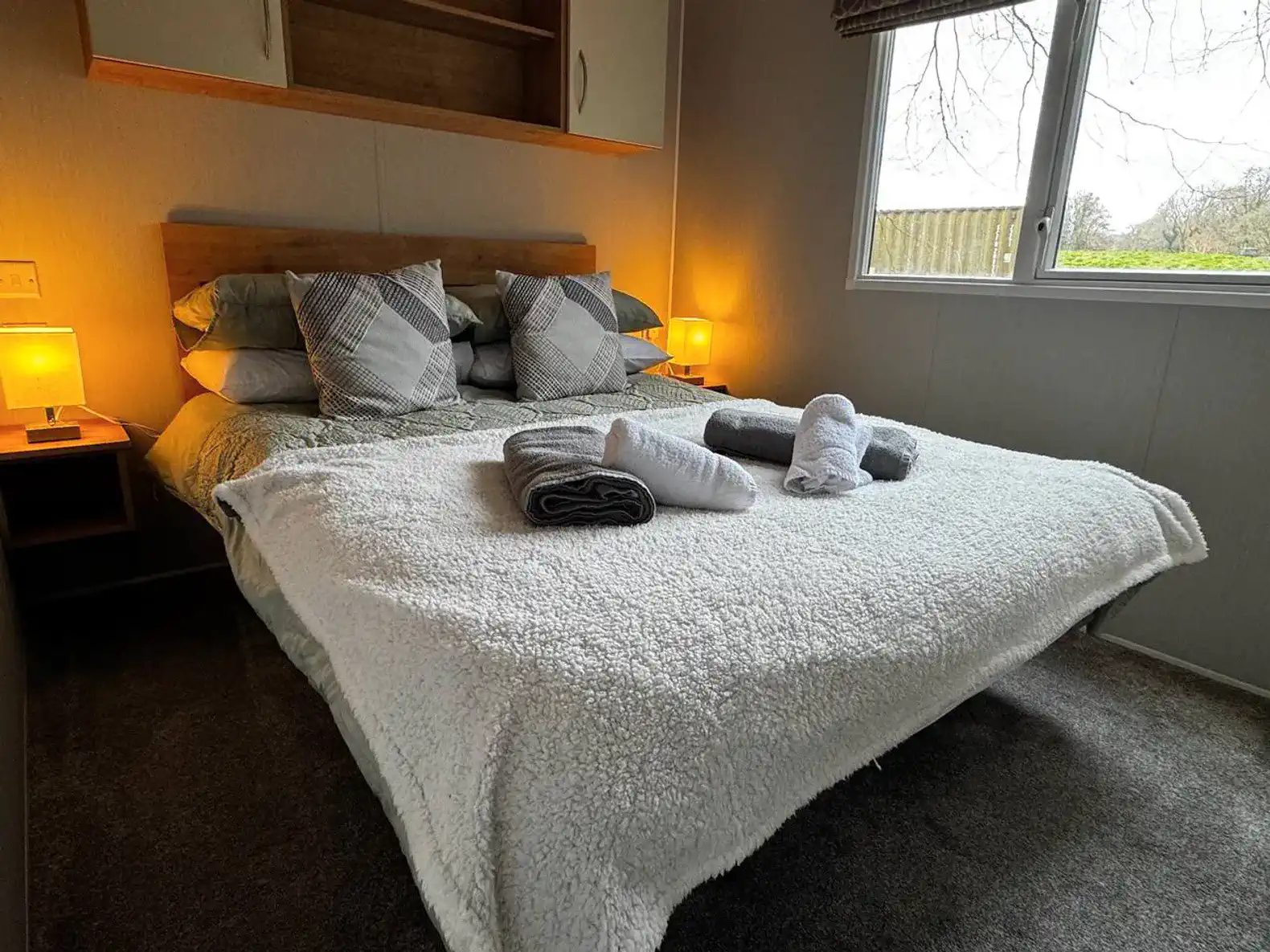 Cozy master bedroom with a large bed, soft blankets, and bedside lamps