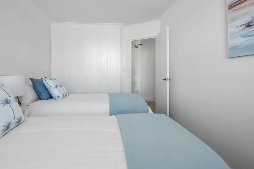 Second bedroom with two long single beds plus a single folding bed
