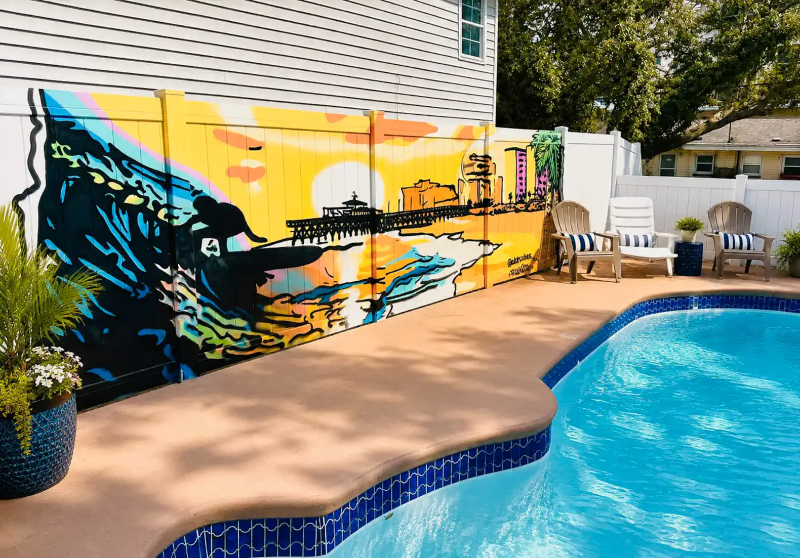 Colorful mural by the poolside with lounge chairs and vibrant sunset theme