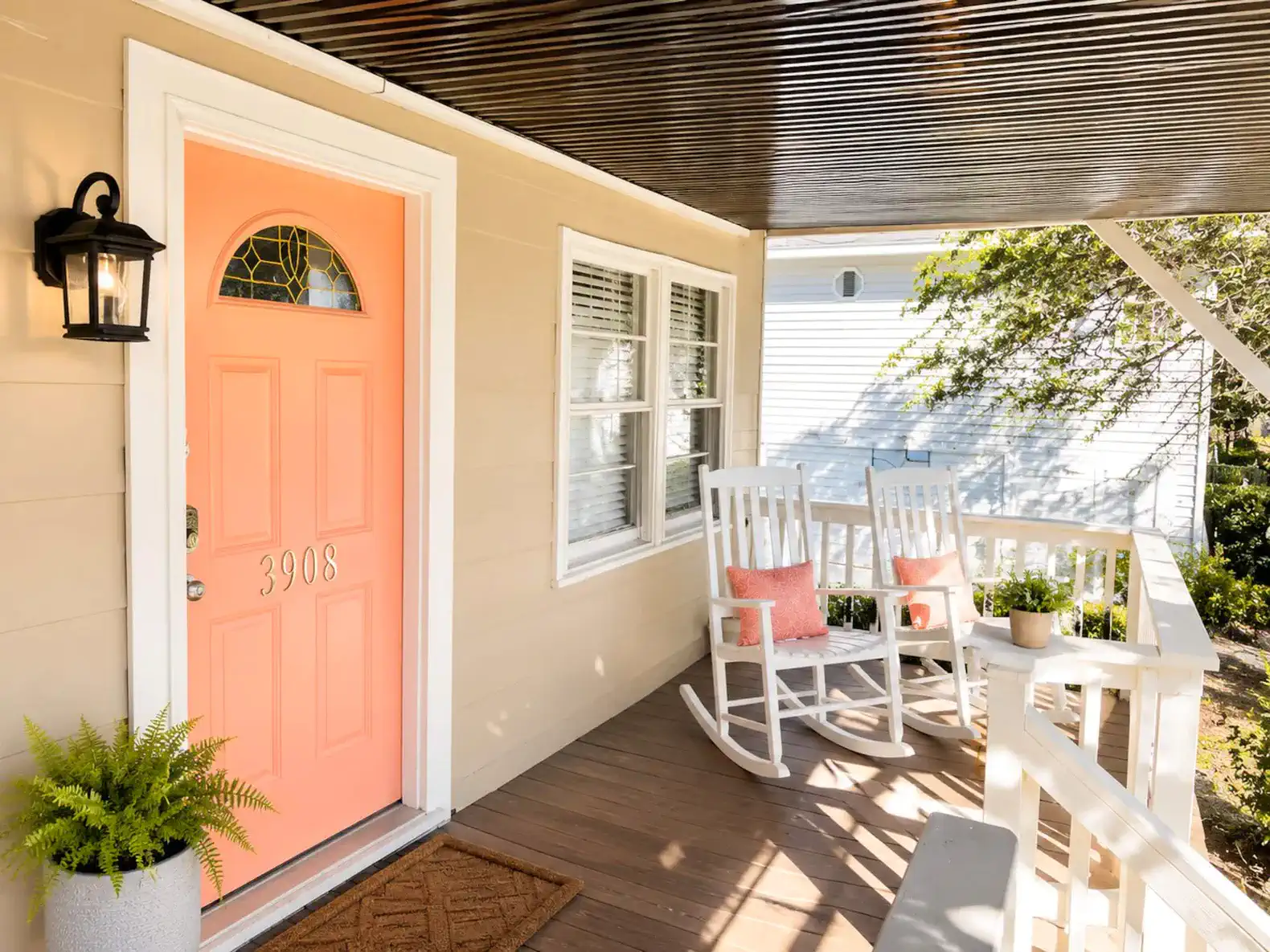 Charming porch with rocking chairs and a bright coral door