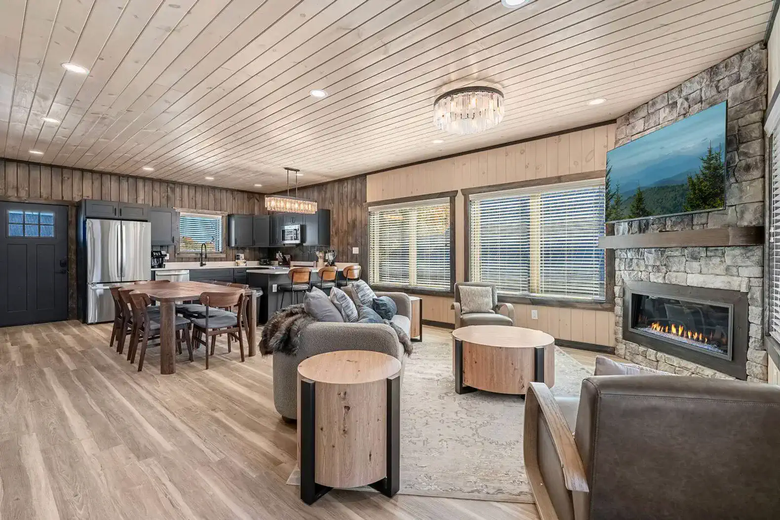 Spacious living area with modern furnishings, fireplace, and dining space