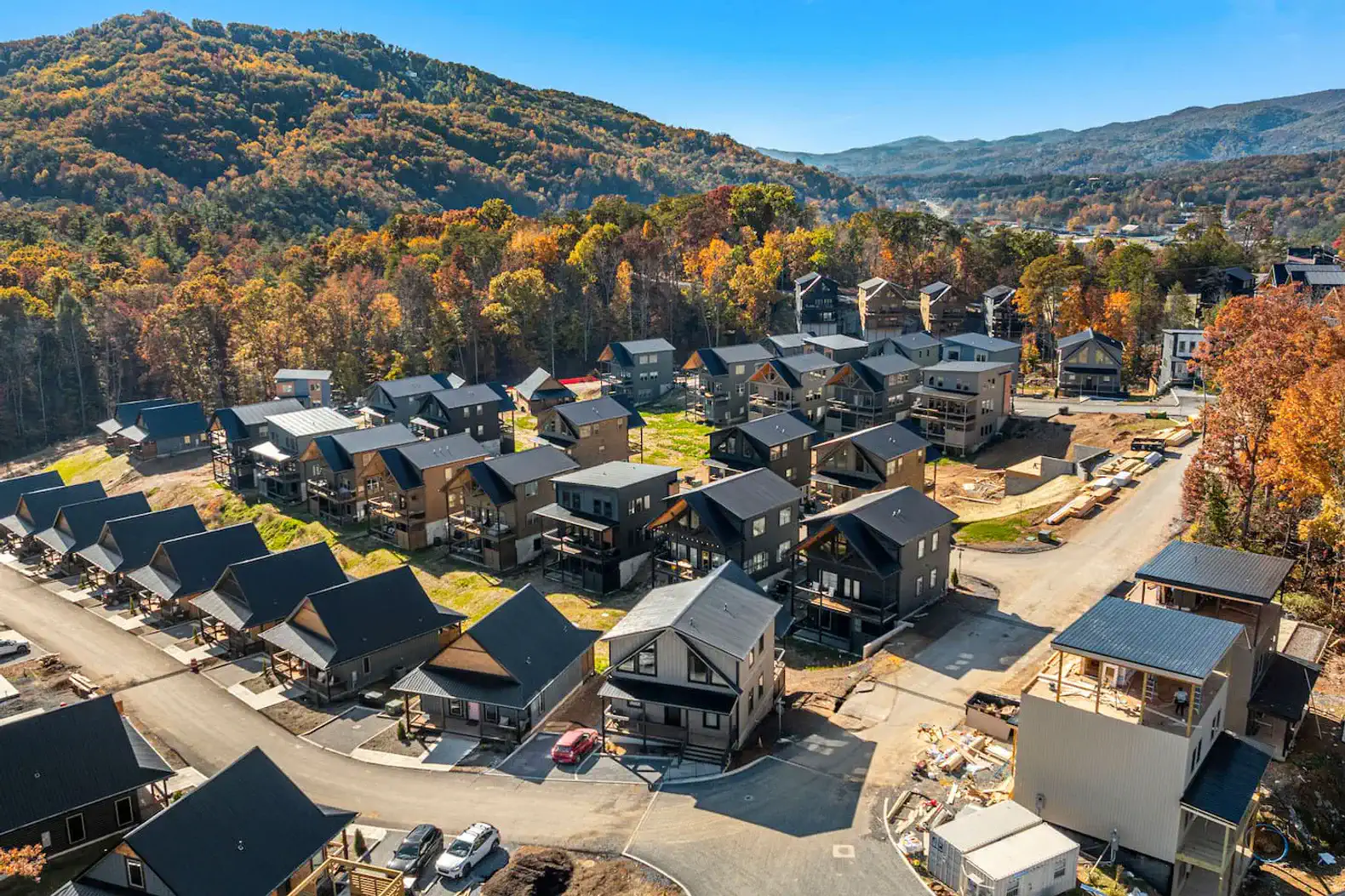 Aerial view of a modern cabin community surrounded by autumn foliage