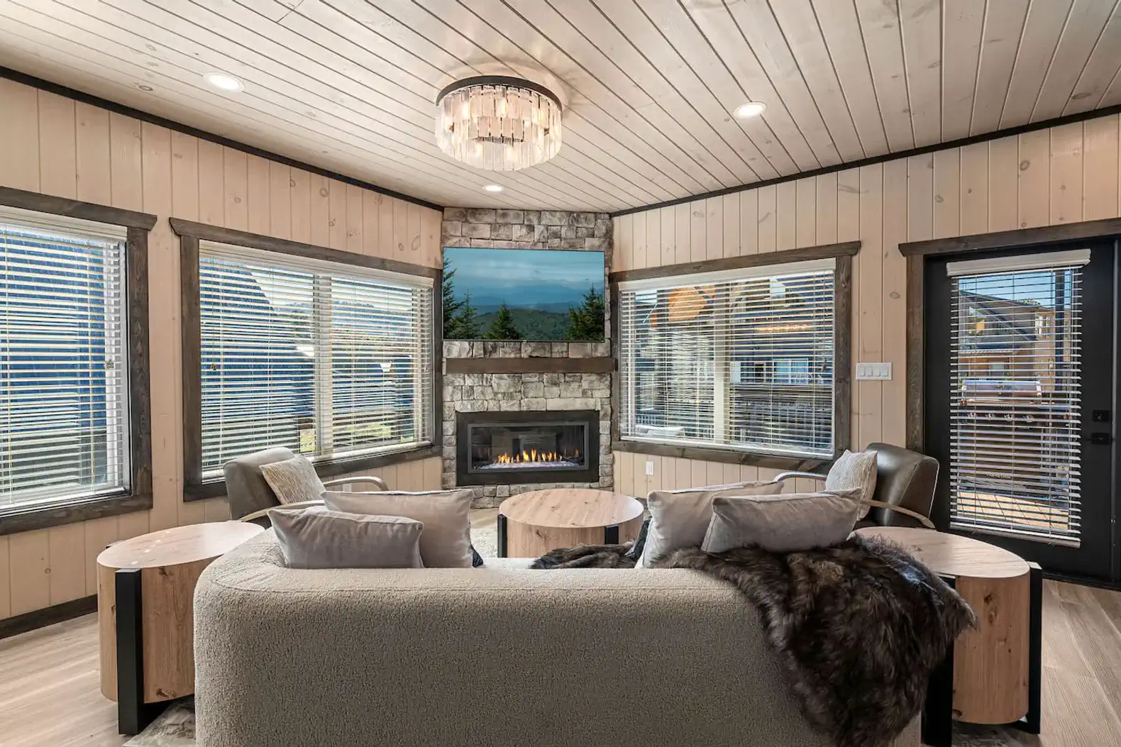 Cozy living room with stone fireplace and mountain views through large windows