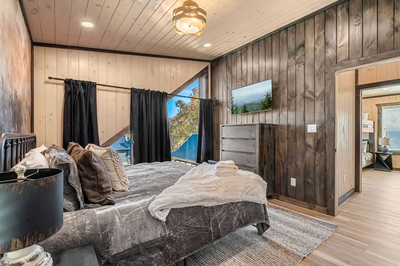 Second level king bedroom with ensuite full bath, smart TV, and clothing storage. 