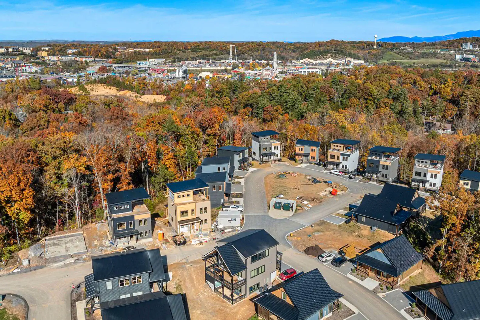 Aerial view of a neighborhood with modern cabins surrounded by autumn foliage