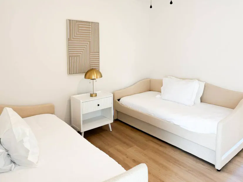 Cozy guest bedroom featuring two twin beds and a stylish nightstand