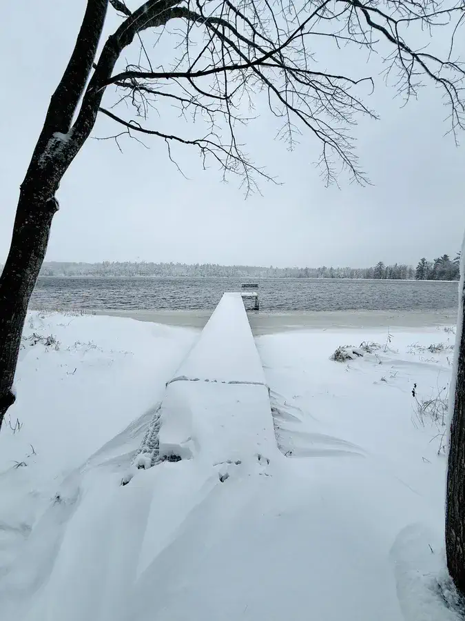 Snow-covered dock and bench at the edge of a frozen lake near Stone Lake, WI