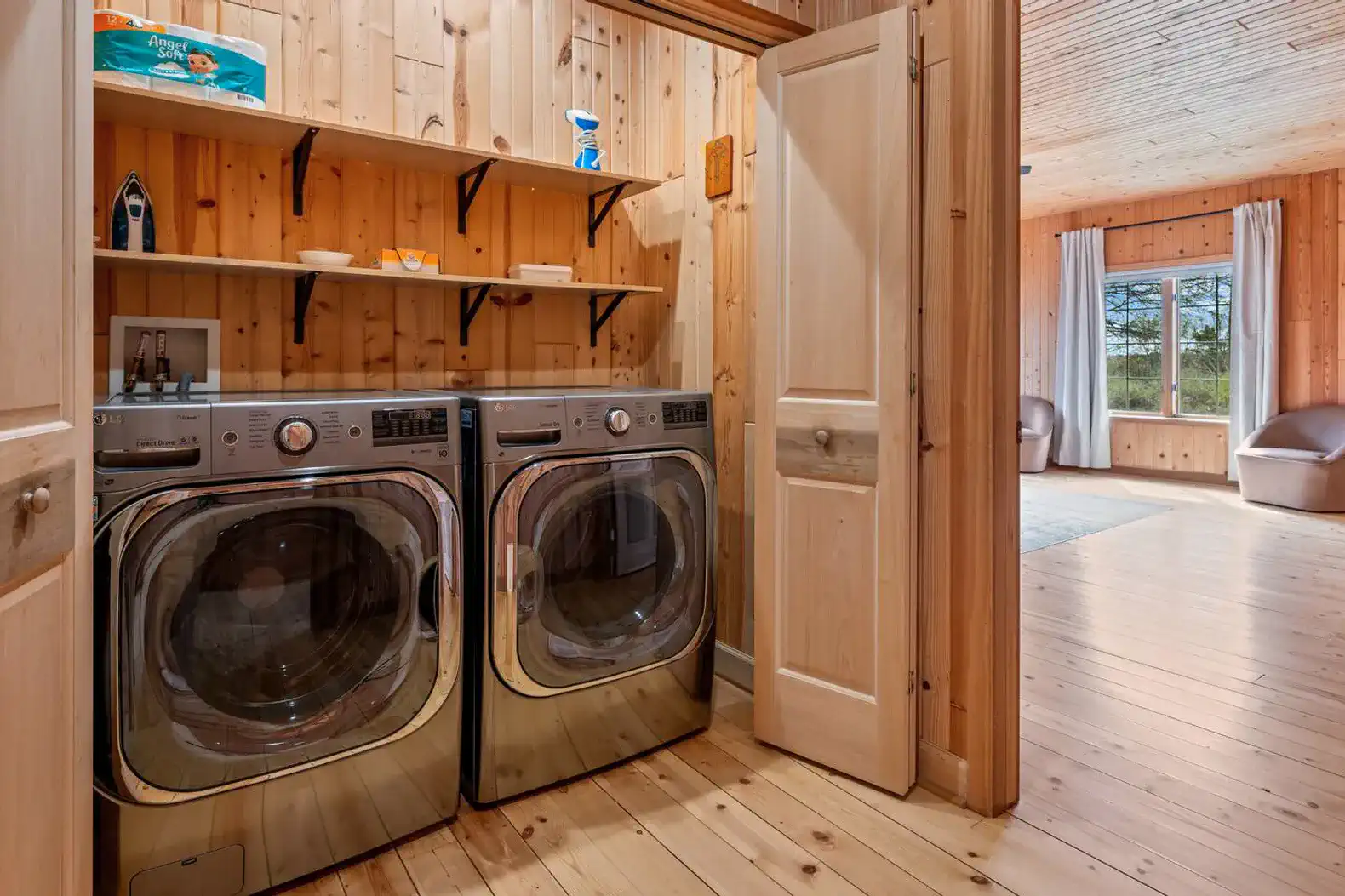 Main-floor full-size washer and dryer with laundry pods, plus an iron, steamer, and first aid kit.