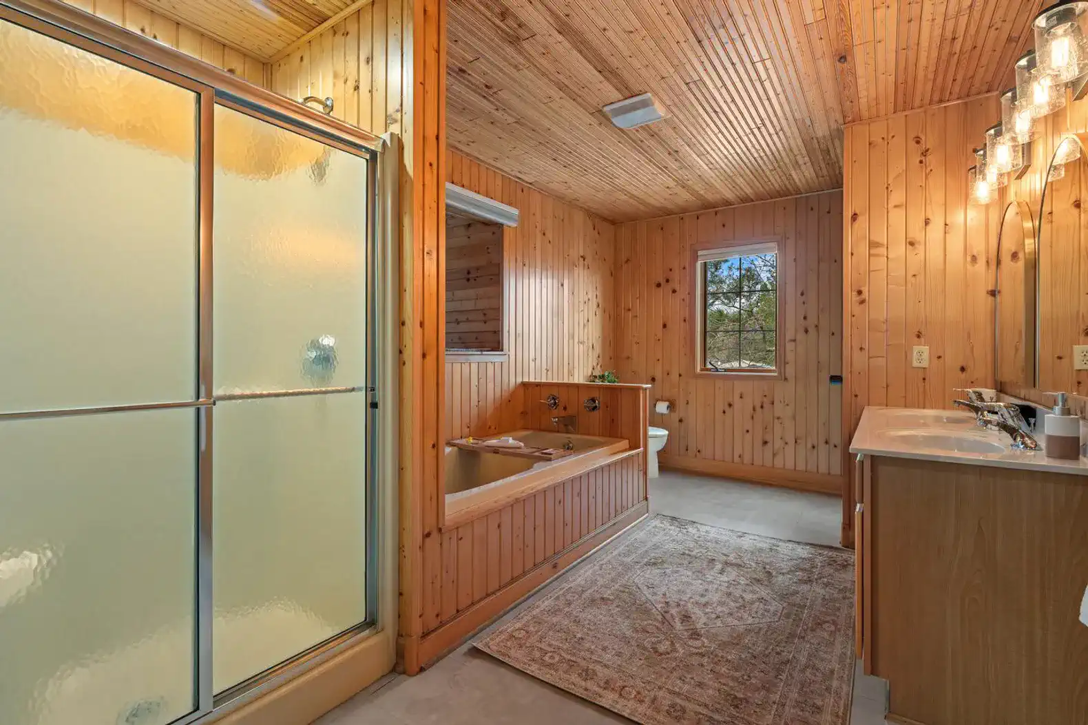 Second-floor authentic cabin bathroom featuring a large tub, separate shower, fresh linens, and essential toiletries.