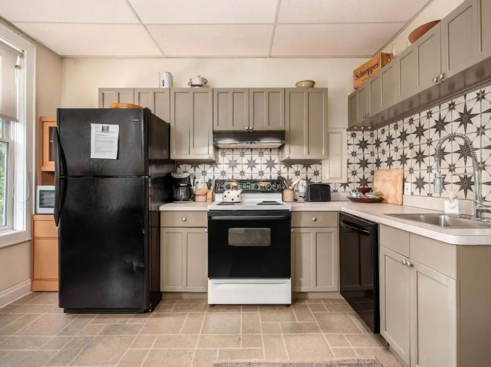 Modern kitchen with black appliances and patterned backsplash