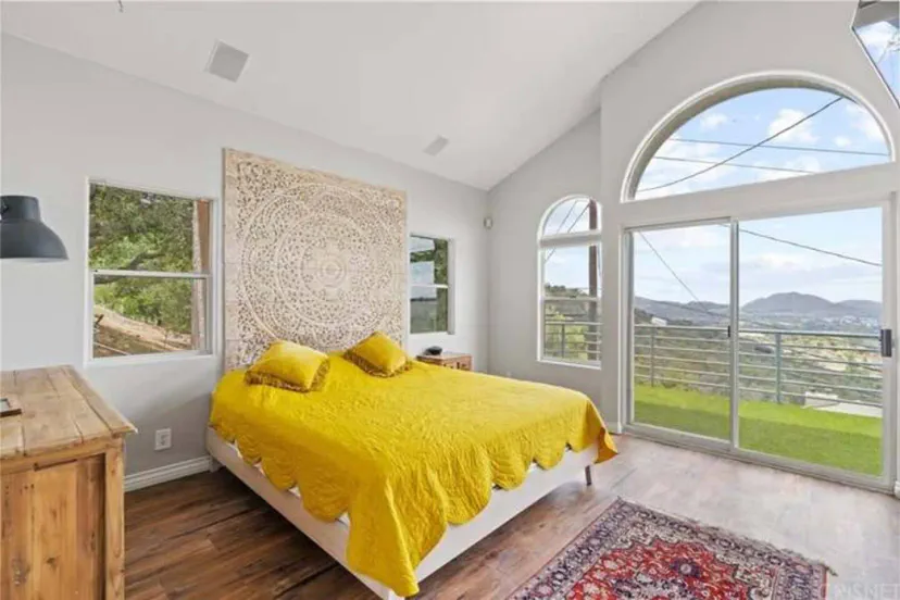 The bed is positioned against a white-painted wall, creating a striking contrast and enhancing the room's brightness.