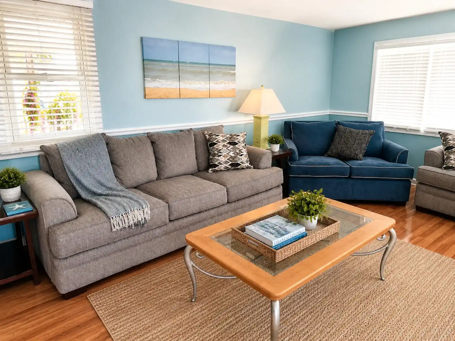 Cozy living room with gray sofa, blue armchair, and beach-themed decor