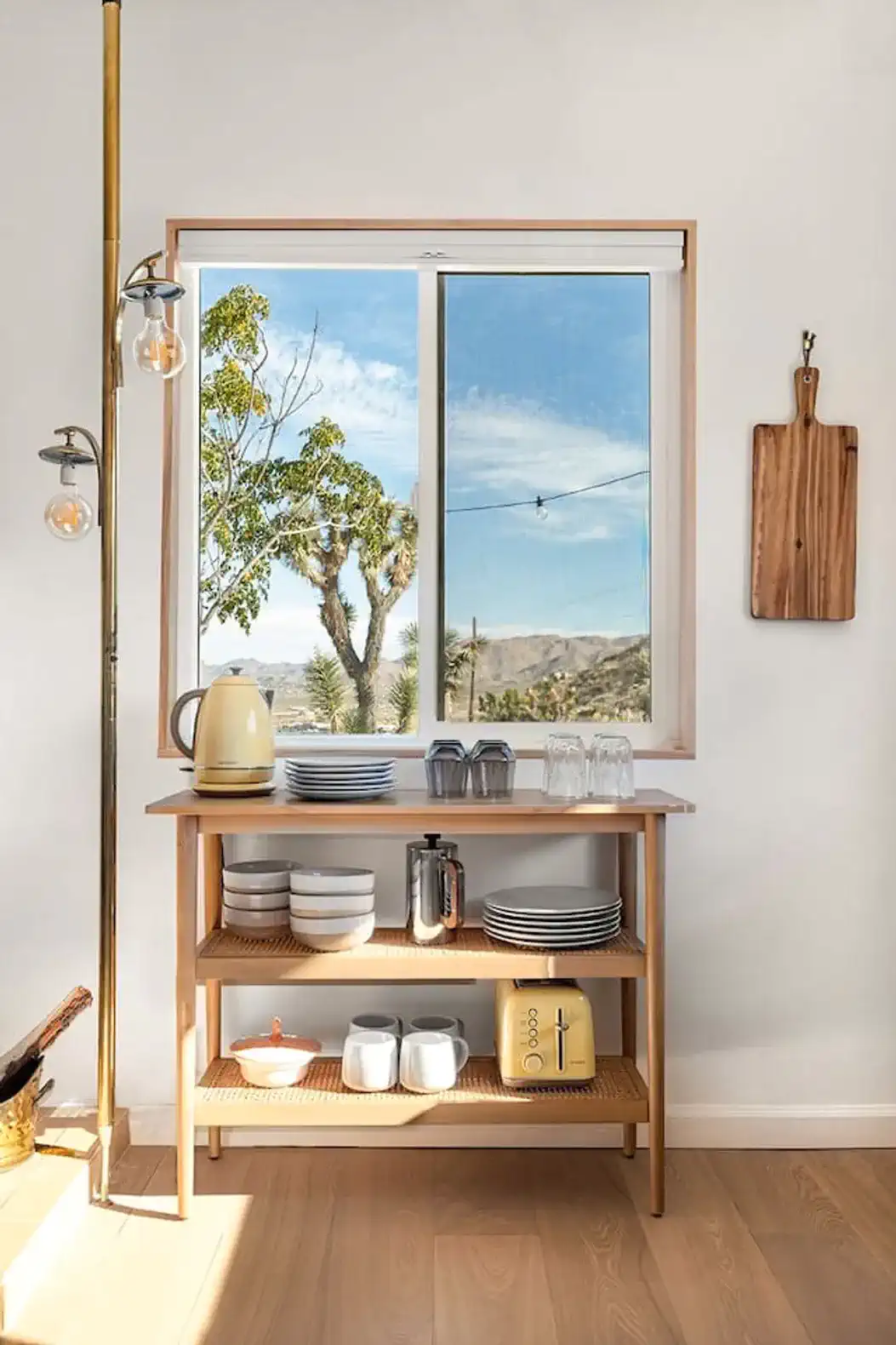 Stylish kitchen nook with a window view, wooden shelves, and modern appliances