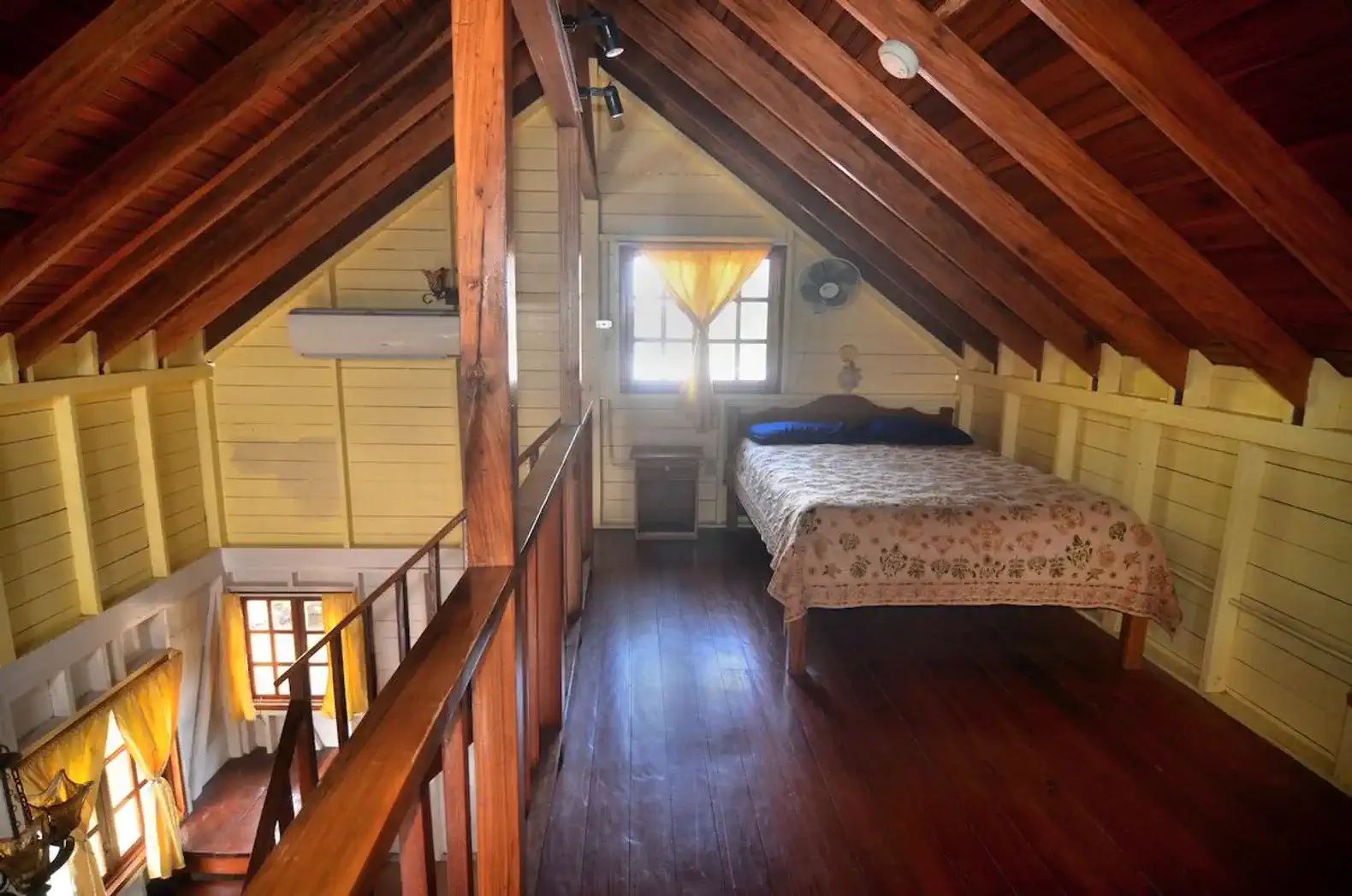 Cozy loft bedroom with wooden beams and a sea view window