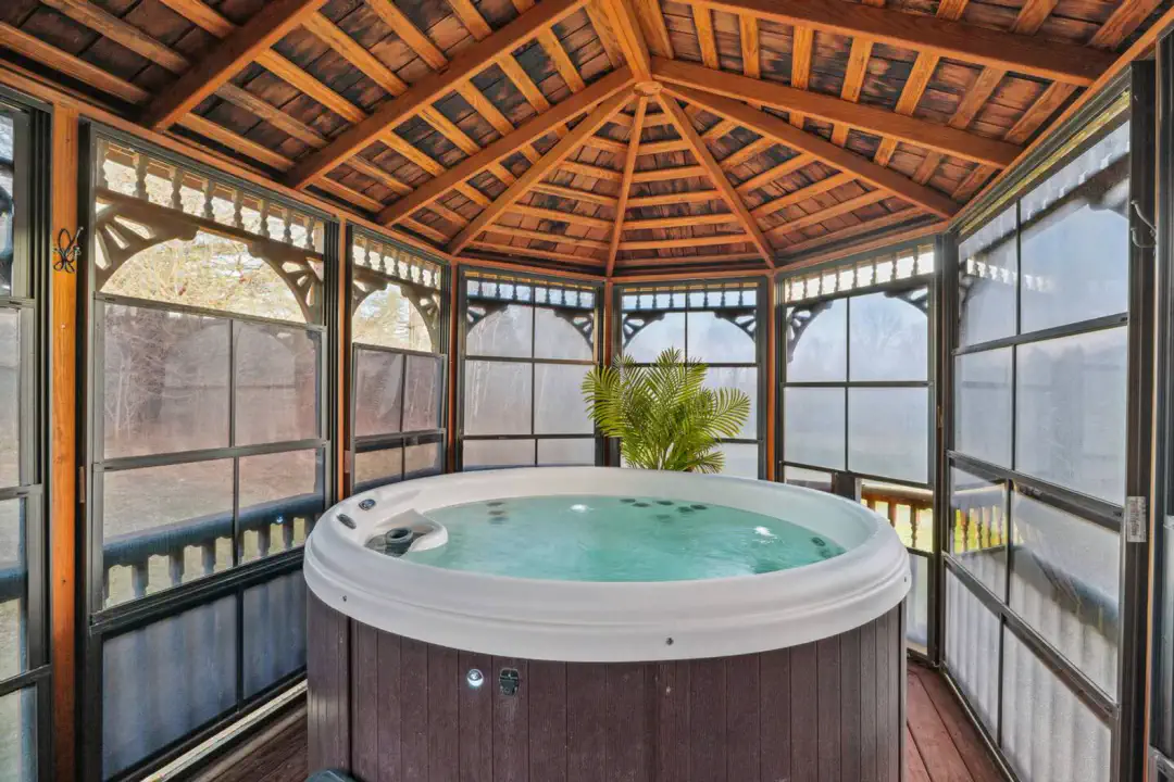 Relaxing hot tub in a screened gazebo surrounded by nature