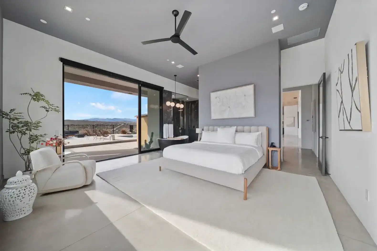 Spacious master bedroom with large windows and mountain views