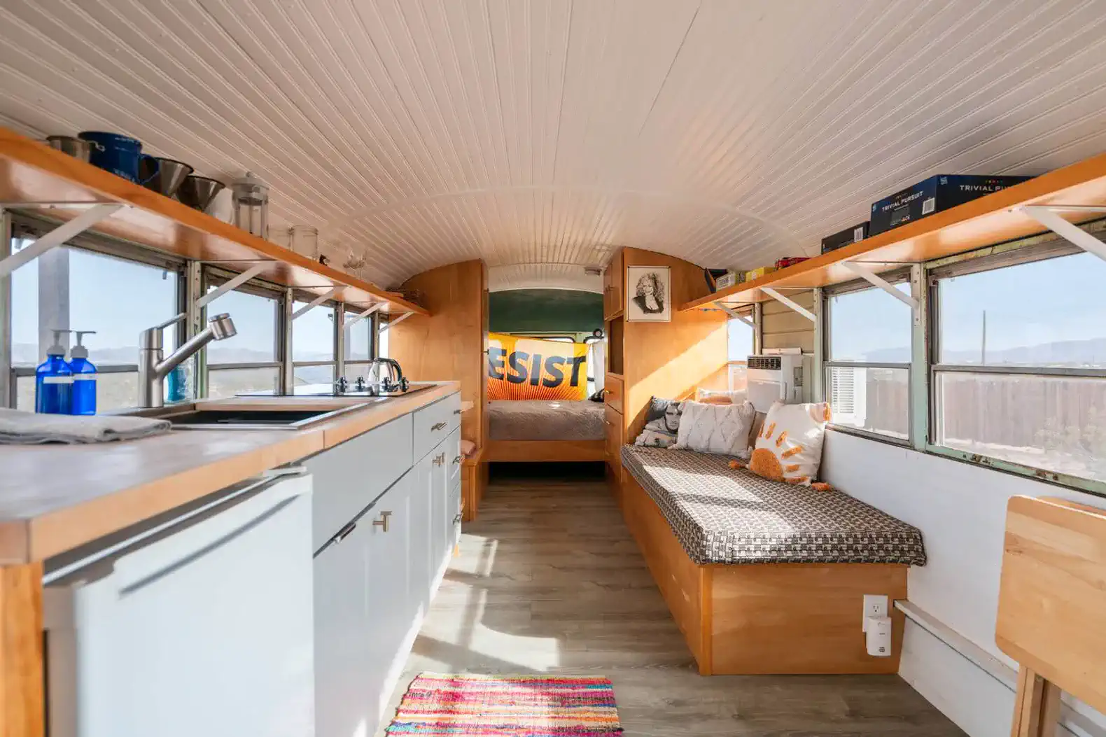 Cozy interior of a converted bus with kitchen and seating area