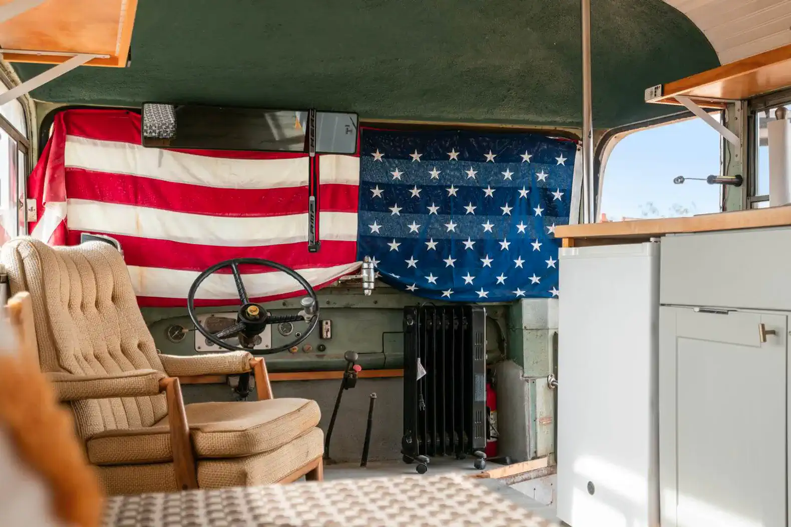 Cozy interior of a vintage bus with American flag decor and a comfortable chair