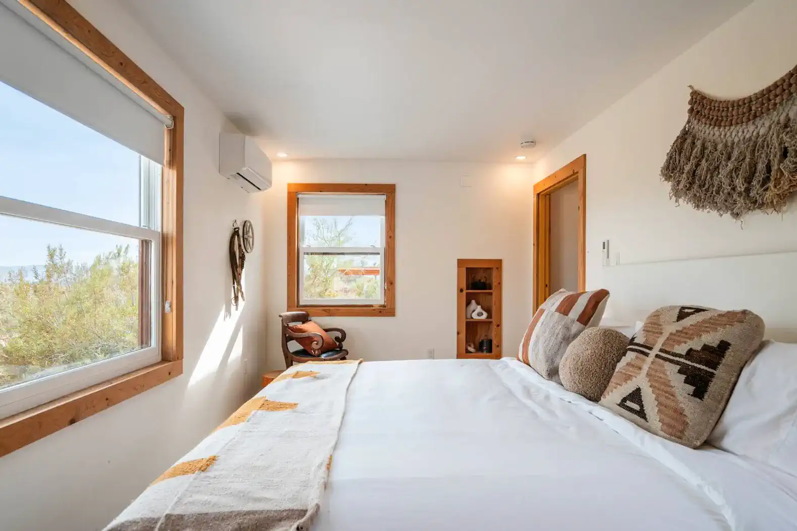 Cozy master bedroom with a large bed, decorative pillows, and natural light from windows