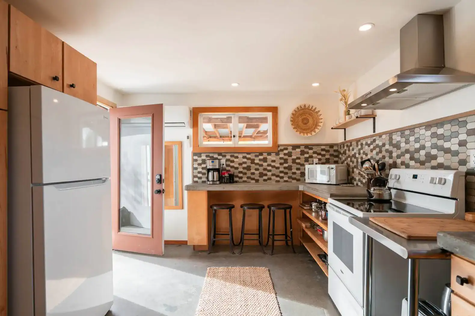Modern kitchen with stainless steel appliances and hexagonal tile backsplash