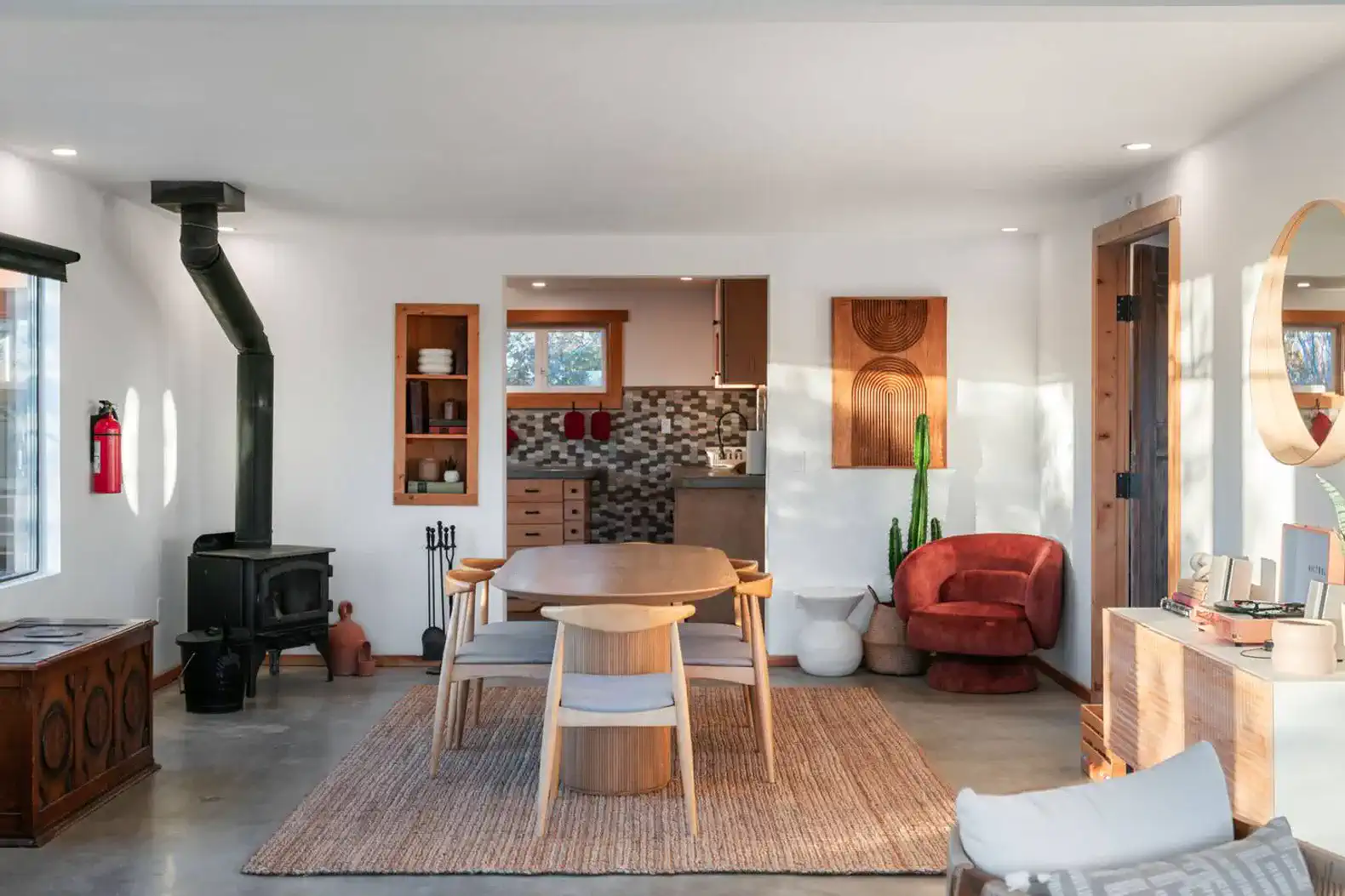 Modern dining area with wooden table, cozy seating, and stylish decor