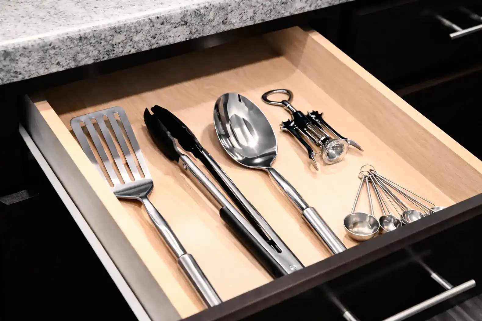 Convenient utensil drawer stocked with tongs, ladles and everyday cooking tools.
