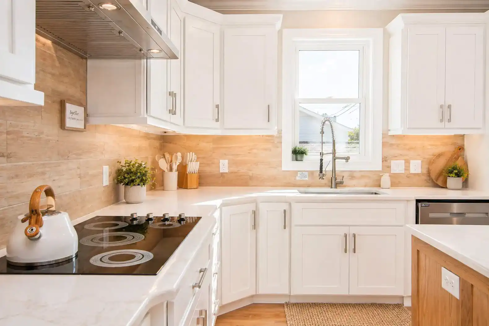 Modern kitchen with white cabinets, quartz countertops, and stainless steel appliances