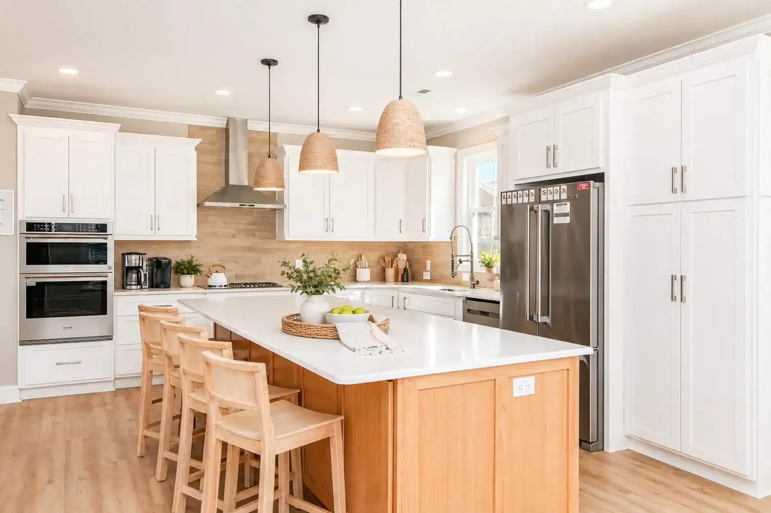Modern kitchen with white cabinets, large island, and pendant lighting
