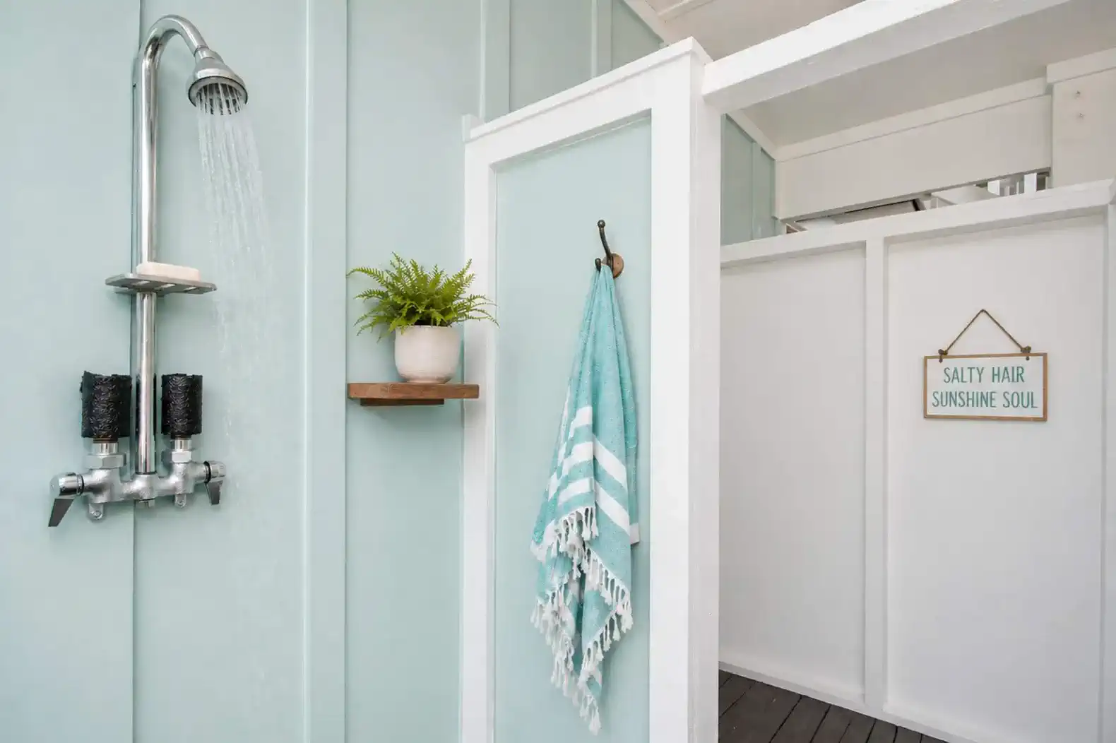 Outdoor shower with teal walls and decorative elements
