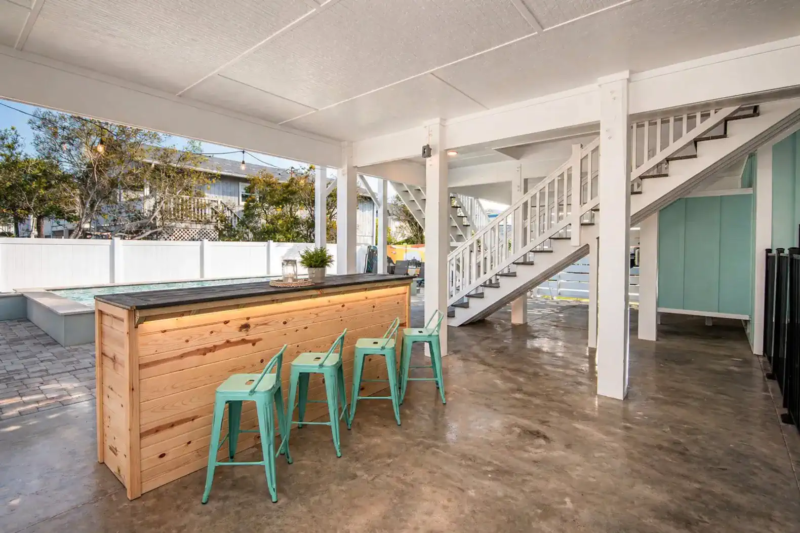 Outdoor bar area with seating and stairs leading to upper level