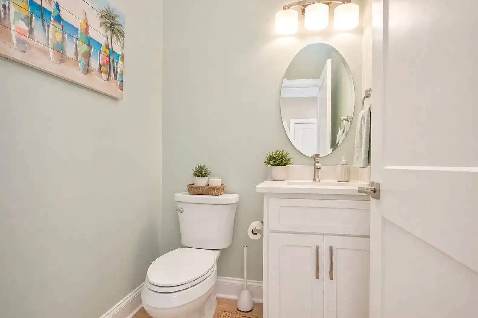 Bright and modern half bath with a round mirror and stylish fixtures