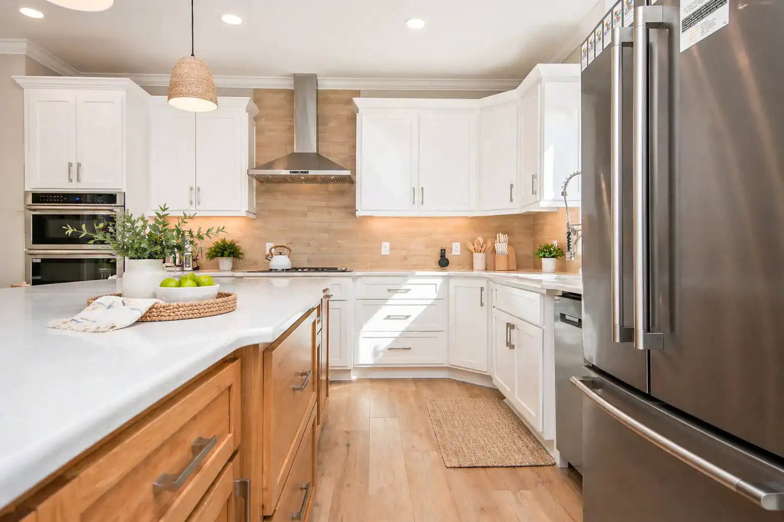 Modern kitchen with white cabinets, stainless steel appliances, and a large island