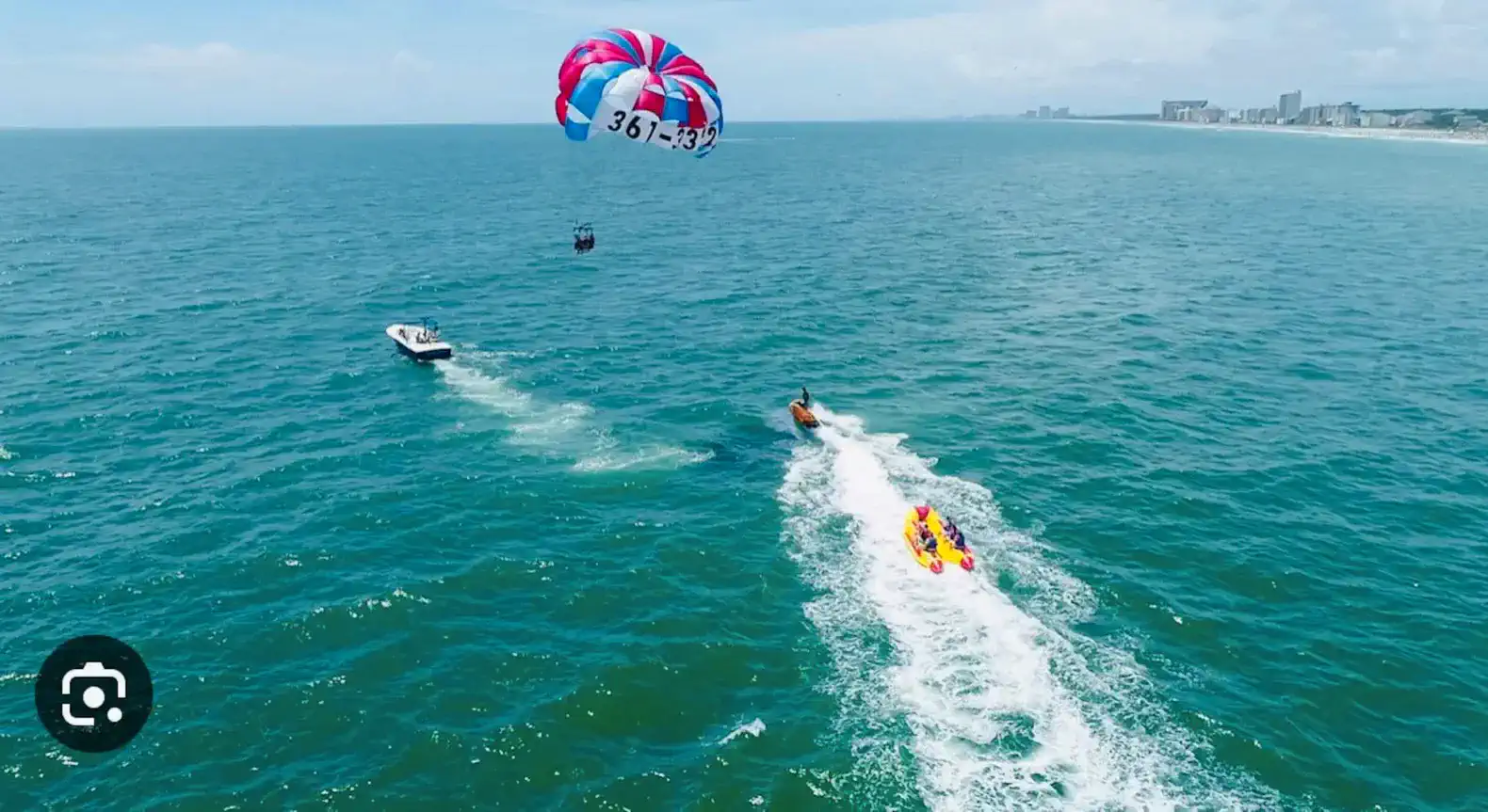 Colorful parasailing above the ocean with boats nearby