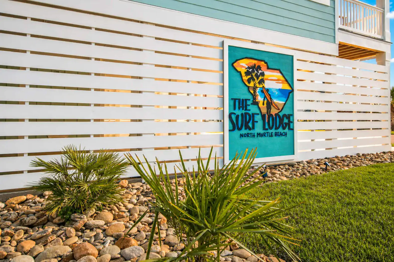 Colorful sign for The Surf Lodge with tropical design and landscaping